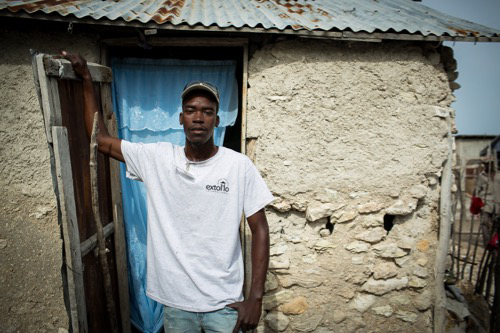 Haitian man in front of his home.